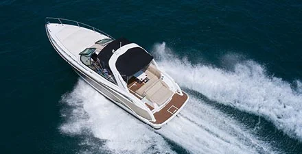 White speedboat cruising across the water, leaving a wake behind.