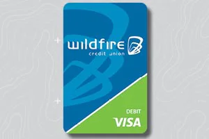 Blue and green Wildfire Credit Union debit Visa card on light background.