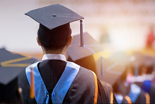Graduate standing among fellow graduates at ceremony
