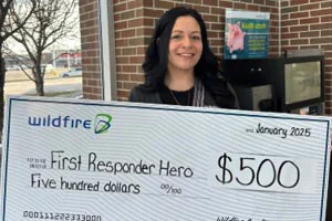 Samantha Rabun holding a large check from Wildfire Credit Union.