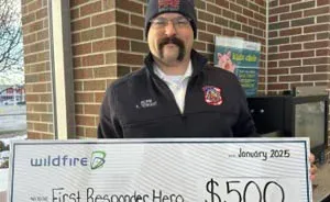Andrew Tennant holding a large check from Wildfire Credit Union.