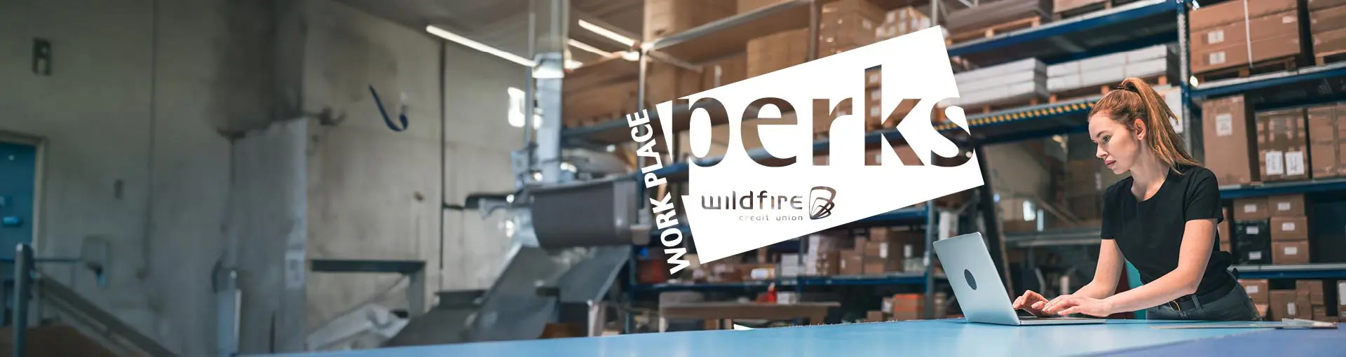 Woman working on a laptop in a warehouse with "Workplace Perks – Wildfire Credit Union" text overlay.